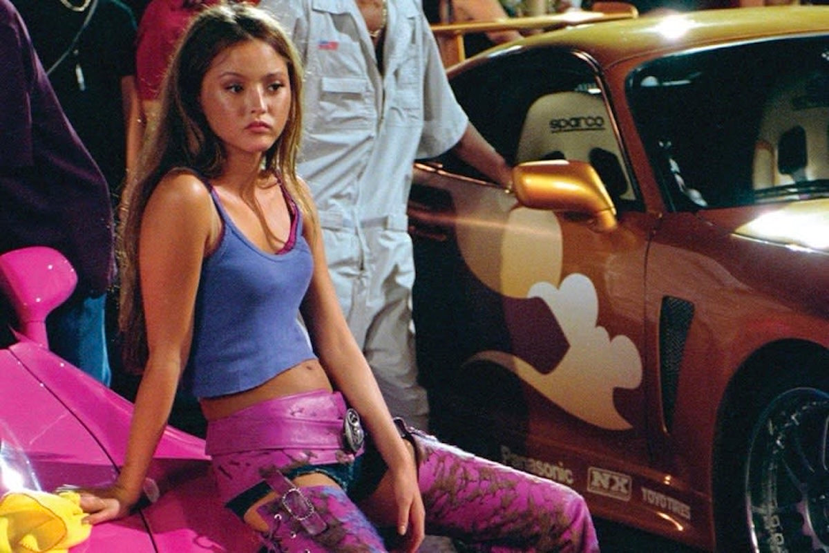 devon aoki sitting on pink car